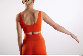 Unaisa  1 arm back view dressed flexing orange sports…